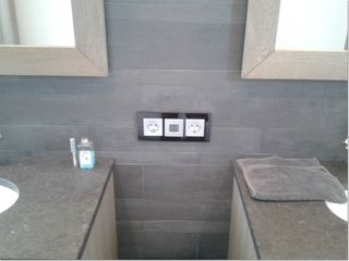 Wandcontactdozen en een bedieningspaneel tussen twee wastafels