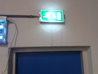 LED-noodverlichtingsarmatuur met vluchtwegpictogram boven een deur